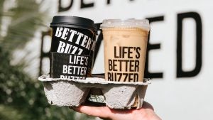 hand holding two coffee cups